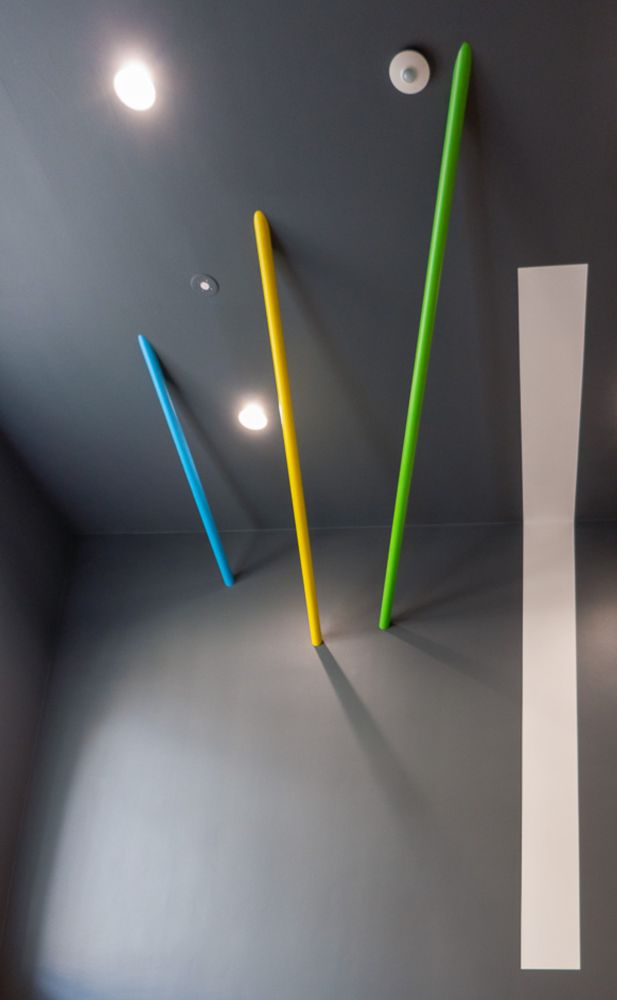 Farbige Linien setzen lebendige Akzente auf der anthrazitfarbenen Wand.